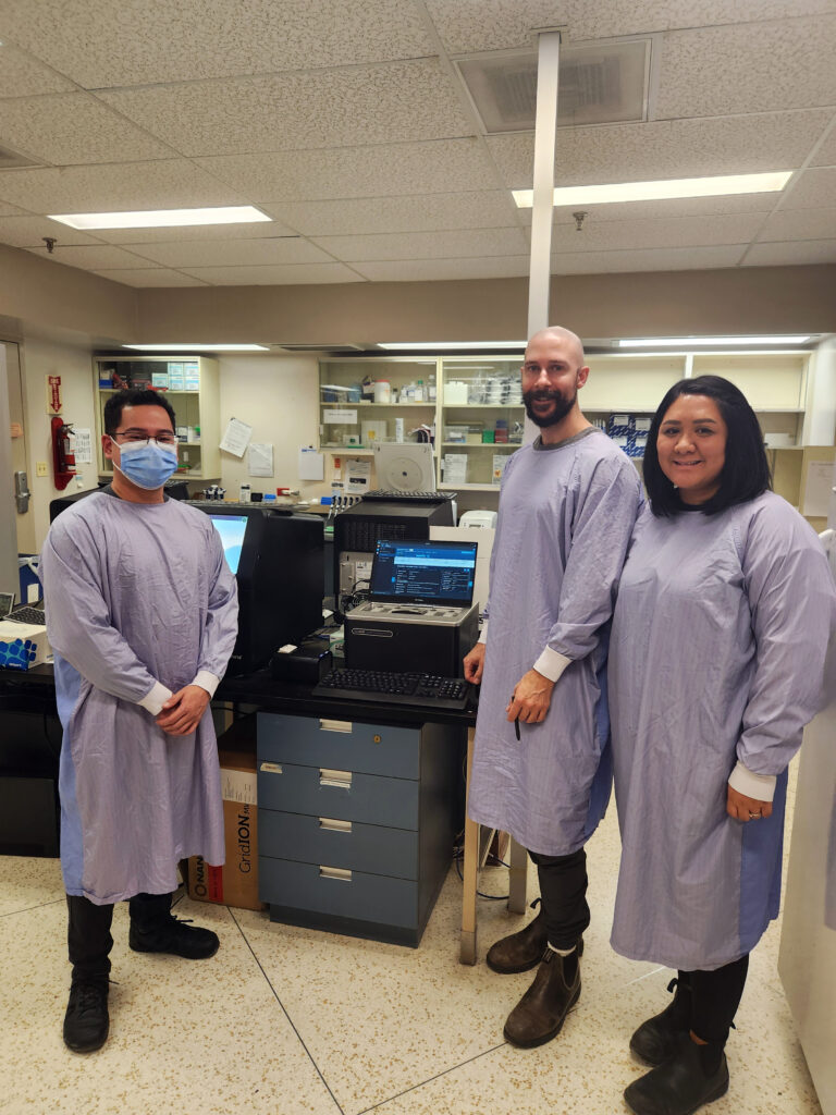Les techniciens de laboratoire Vince Benedicto, Brendan McKenzie et Edlyn Dunlop par l’Oxford Nanopore GridIon.