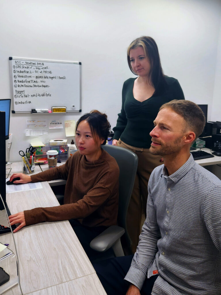 Scientists Jenny Tran, Logan Tate and Franz Fenninger examine test results.
