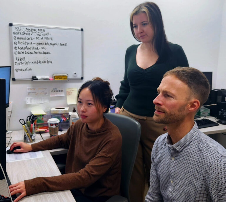 Scientists Jenny Tran, Logan Tate and Franz Fenninger examine test results.